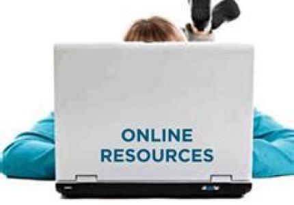 Online Resources written on a lid of a laptop with person lying behind laptop