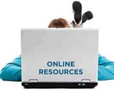 Online Resources written on a lid of a laptop with person lying behind laptop
